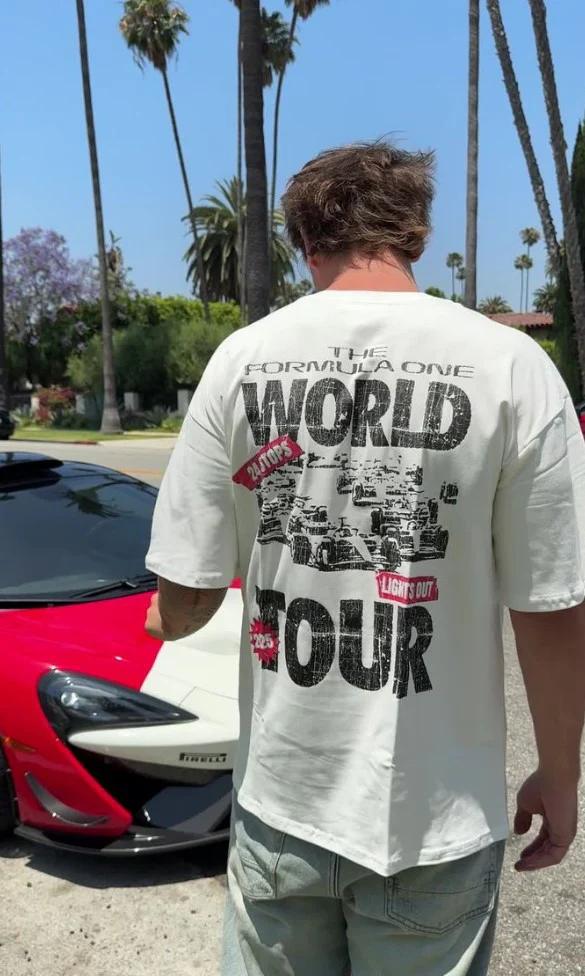 Customer wearing Formula One World Tour tee next to a red McLaren